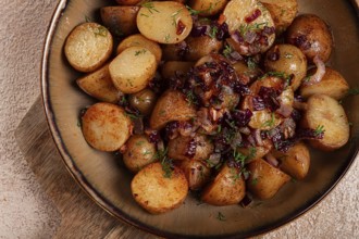 Golden roasted potatoes are enhanced with caramelized onions and fresh herbs, creating a savory