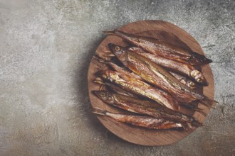 Cold smoked capelin, on a wooden bowl, top view, no people