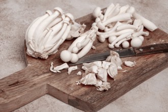 Freshly sliced Shimizhi mushrooms, on a wooden chopping board, ready to cook, close-up, no people