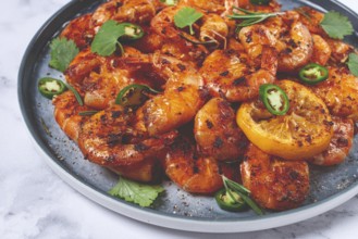 Grilled shrimp, unpeeled, headless, with spices, on a marble table, homemade, no people