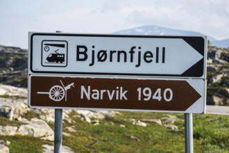 Signpost to Bjørnfjell railway station, railway line Kiruna-Narvik, and world war II memorial,