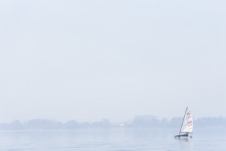 Ice sailor on frozen Dümmer Lake, on a fog-covered lake, quiet and peaceful winter landscape,