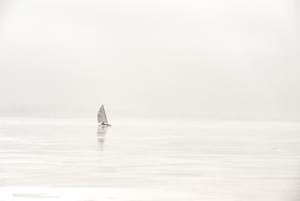 Ice sailor on the frozen alone on a foggy, frozen lake, minimalistic winter atmosphere, Dümmer See,