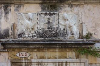Relief of a coat of arms framed by two sphinxes on a historic palazzo, Venice, Veneto, Italy