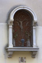 Devotional niche with a Jesus cross behind an ornate grid, Venice, Veneto, Italy