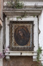 Sacred image of the Madonna in a latticed niche, Venice, Veneto, Italy