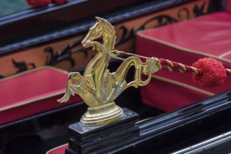 Mythological horse figure made of brass and red pompoms decorate the gondola, Venice, Veneto, Italy