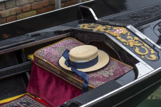 Typical straw hat of a gondolier sitting on a gondola, Venice, Veneto, Italy