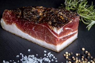 Ham bacon piece on slate plate with salt and peppercorns, delicacy ham fresh from the butcher