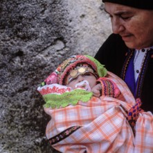 Easter Sunday, grandmother holding little girl in festive traditional dress, Olymbos, Karpathos,