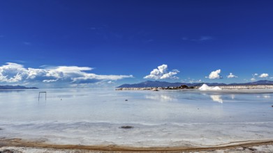 Wide view of a salt lake with blue sky and few clouds, The Salar de Cauchari salt pan near Salta in