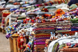Stacked, colorful blankets and hats at a sales stand, tourist and souvenir market in Santa Rosa de