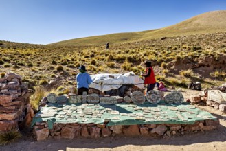 Archaeological excavation in the Andes with handicrafts and stones, surrounded by hills under blue