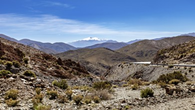 Winding road through a mountainous and dry landscape under blue sky, roads through the Quebrada de