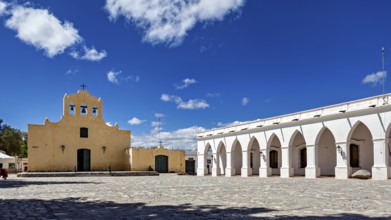 Square in front of a yellow church with arcades and blooming sky, quiet atmosphere, Iglesia San