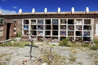 Weathered wall with grave niches and cross in an old cemetery, The cemetery of Cachi in Argentina
