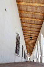 Long, covered corridor with wooden ceiling, simple colonial architecture, The arcades of Cachi in