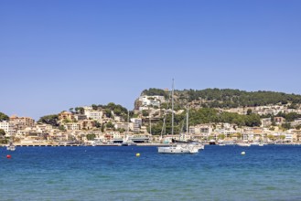 Scenic view of a coastal village with turquoise blue water and anchored sailboats and yachts and a