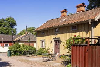 Picturesque Scandinavian courtyard featuring a traditional wooden building with garden furiture on