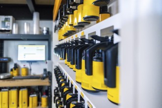 Automotive paint system with rows of yellow and black containers holding varied tints on organized