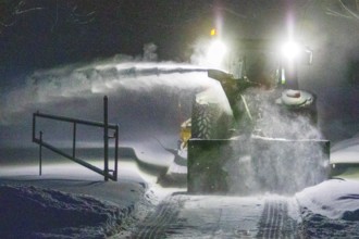 Heavy machinery clearing snow from a property entrance, Region of la Mauricie, Province of Quebec,