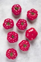 Pink tomatoes scattered on the table, top view, close-up, no people