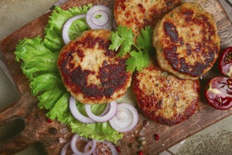 Fried chicken cutlets, minced chicken, with vegetables, on a cutting board, with vegetable salad,