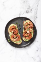 Sandwiches with avocado and caramelized shrimp, micro-greens, breakfast, on a plate, top view,