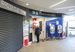Person buying bus ticket inside Plymouth bus station, Plymouth, Devon, England, UK