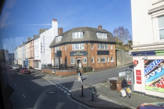 The West Hoe pub street scene viewed from bus window, Plymouth, Devon, England, UK