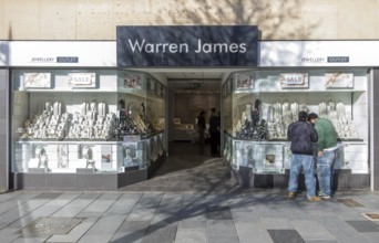 Two men window shopping at Warren James jewellery outlet shop, New George Street, city centre of