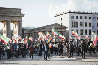 Participants carry Iranian flags from the Pahlavi period and the historic Persian flag during the
