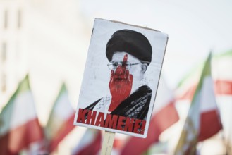 Sign for Khmenei with red middle finger at the demonstration by exiled Iranians under the slogan
