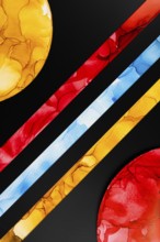 A vibrant abstract image featuring colorful geometric shapes on paper. Bold red, yellow, and blue