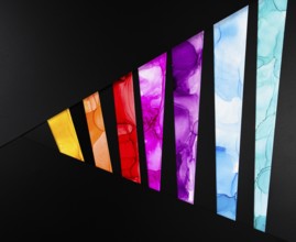 A vibrant geometric pattern with colorful segments on a black background of paper. Each segment