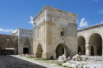 Stone building fragment and courtyard under a clear blue sky, Sultanhani caravanserai, on the