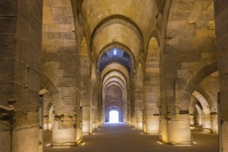 Mighty stone hall with a series of arches and a central light point, Sultanhani caravanserai, on