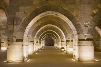 Long stone tunnel with alternating arches in warm light, Sultanhani caravanserai, on the former