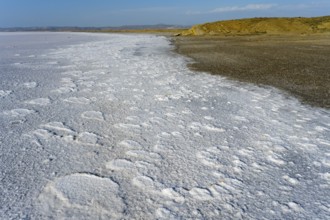 Texturally rich salt flat on the shore of a lake that ends on the horizon far away, Salt Lake, Tuz