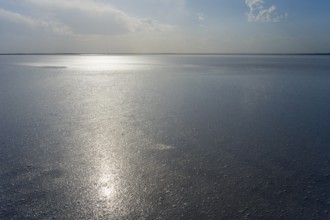 Wide, peaceful expanse of water with bright sunlight and cloudy sky, salt lake, Tuz Gölü, located