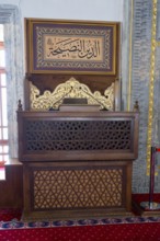 Decorated wooden shrine with Islamic script in a prayer room, minbar or mimber, preaching pulpit,