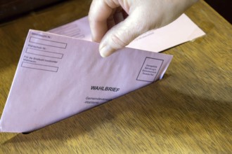 Absentee voting symbol: A ballot letter is thrown into the ballot box of a municipal administration