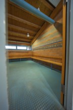 View through an open door into a changing room with brick walls and wooden ceiling, Schlehengäu