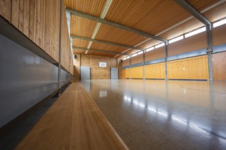 Empty sports hall with wooden walls and a basketball hoop in a quiet atmosphere, Schlehengäu Grund