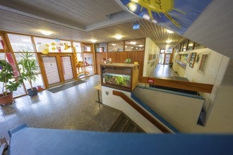 Inviting entrance area with colorful decorations and wooden paneling, Schlehengäu Grund Schule