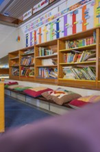 Educational area with well-stocked bookshelf and colorful seating, Schlehengäu Grund Schule