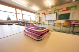 A pencil case is lying on a table in the classroom, window in the background, Schlehengäu Grund