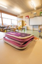 A pencil case is lying on a school desk in the classroom, blurred background, Schlehengäu Grund