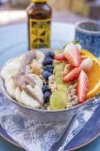 Healthy breakfast with fruit and cereal in a bowl on a table outside, Calw, Calw district, Germany
