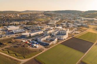 Extensive landscape with modern buildings and fields in the light of a clear morning, new hospital
